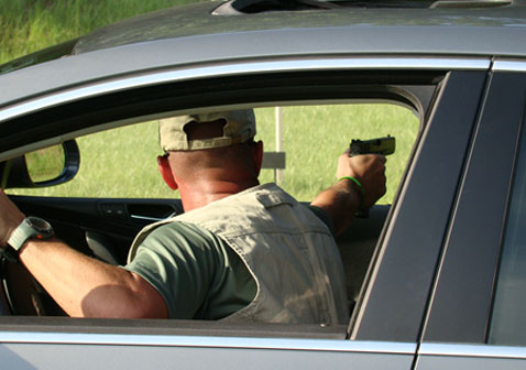 man in car with gun